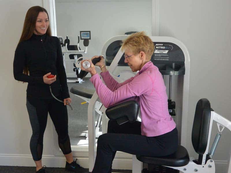 female personal trainer works with client in a private training gym