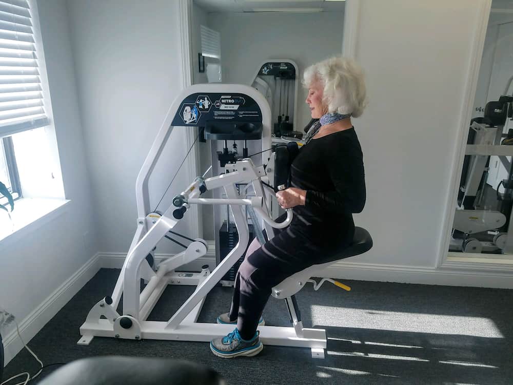 woman using row machine in gym