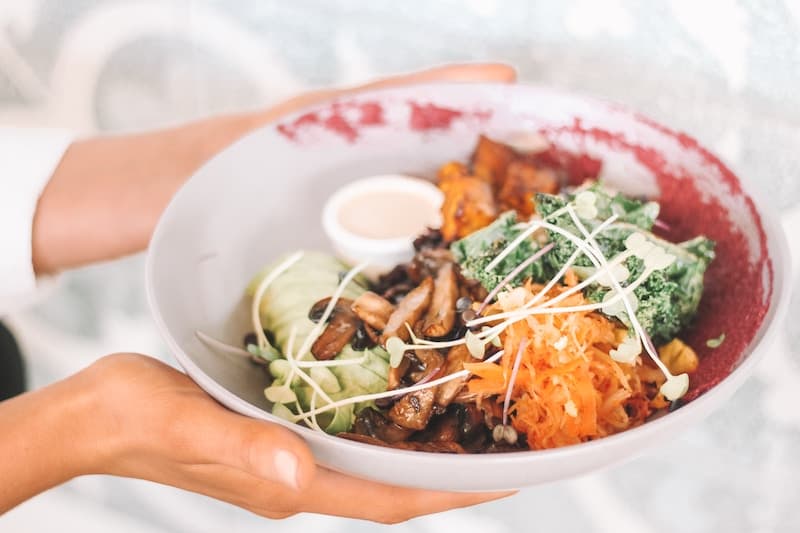 Hands holding bowl of healthy food