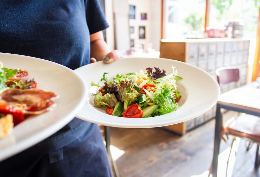 person holding two salad plates