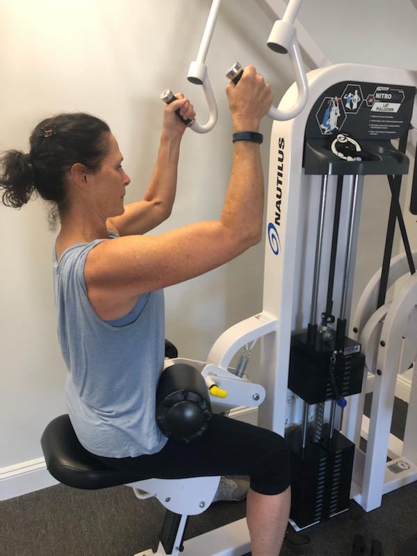 woman doing arm workout on a strength training machine