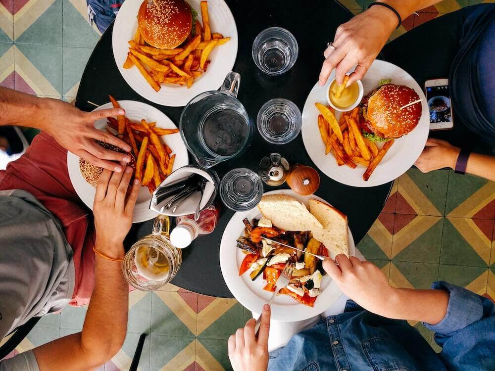 Plates of burgers and fries on a table.