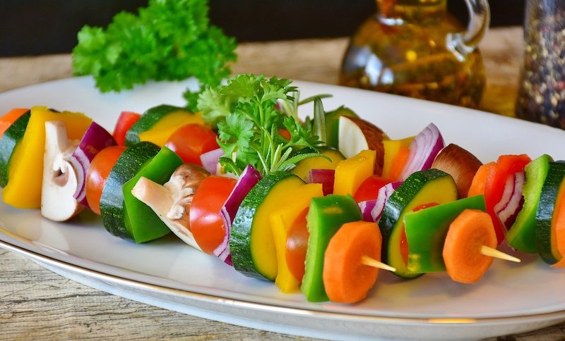 kabob skewers with vegetable slices on a plate