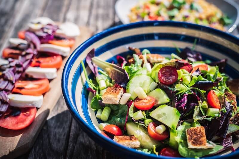 Fresh salad and healthy meal on an outdoor table.