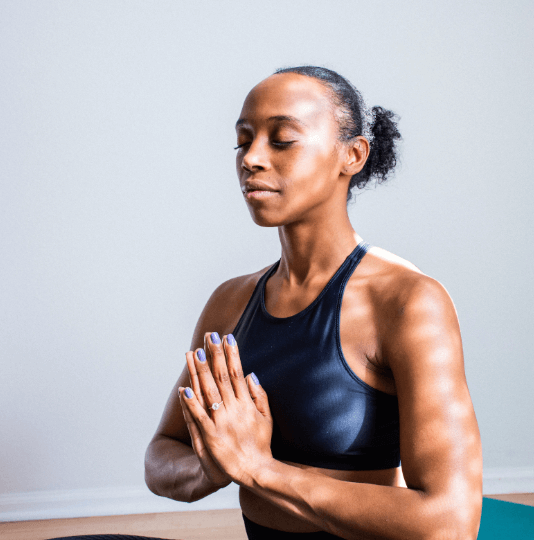 Woman in a yoga studio doing a prayer pose.