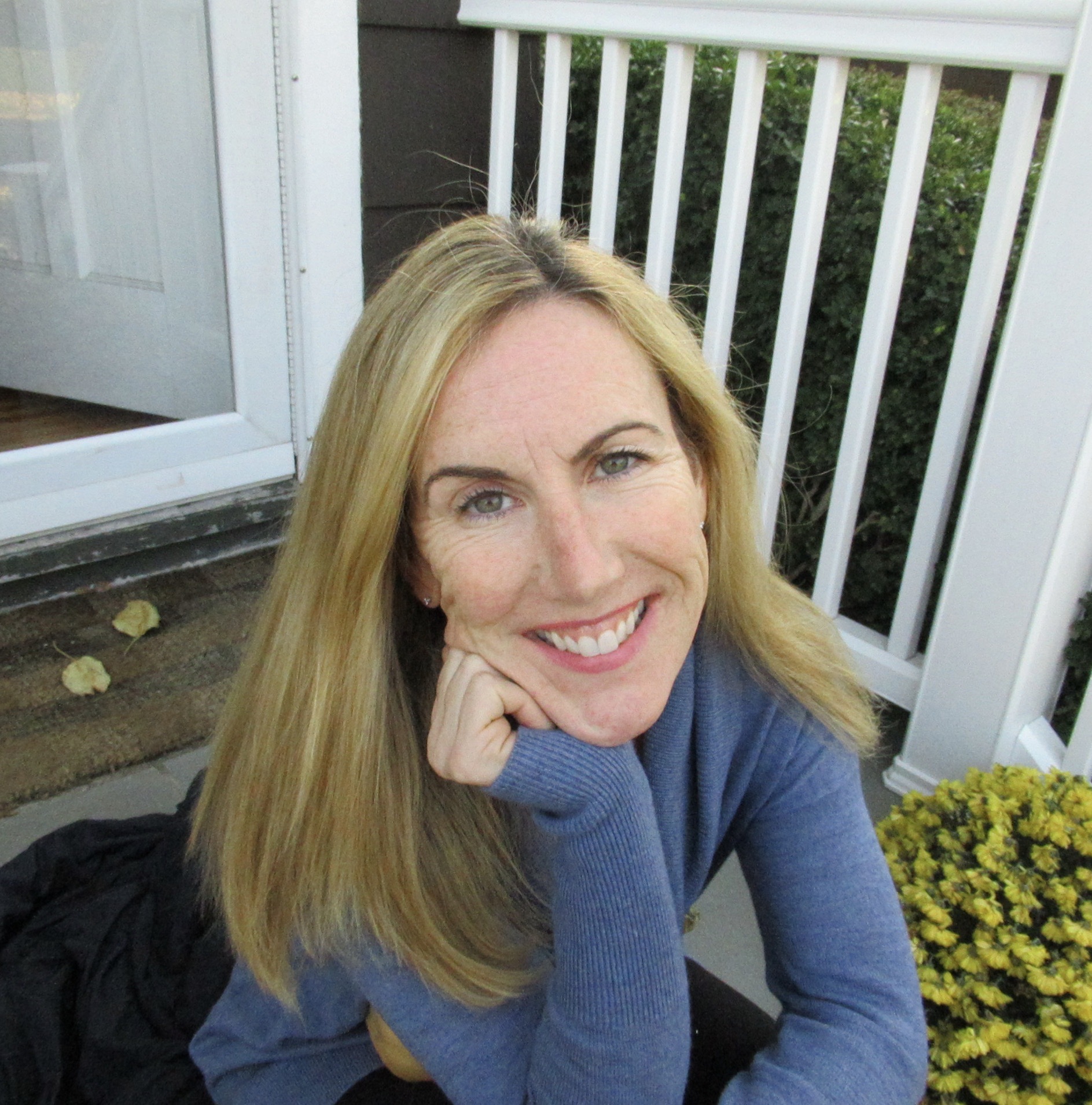 Carolyn Pic A Loyalty Fitness trainer posing with her head resting on her hand.