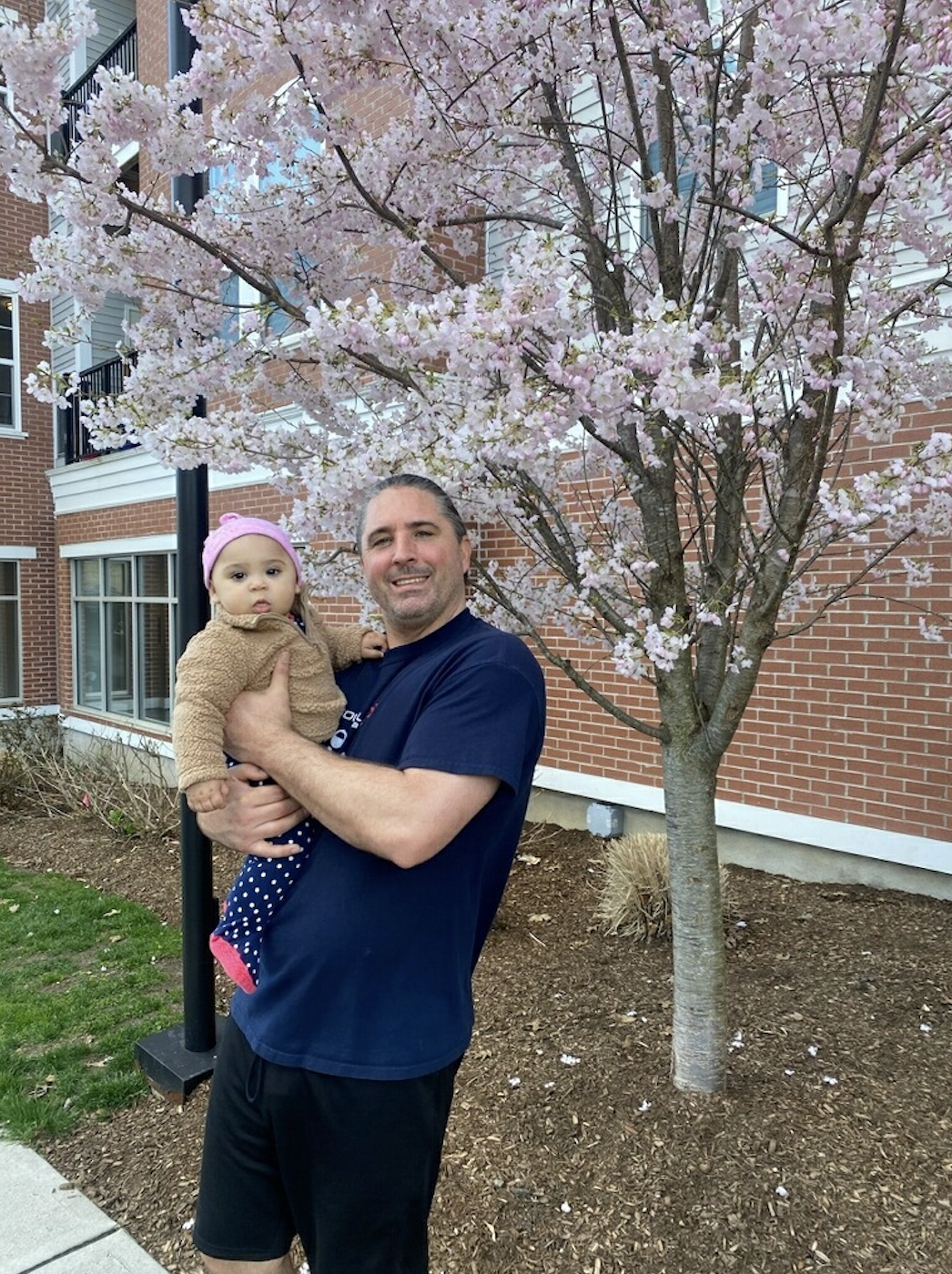 A Loyalty Fitness trainer holding a child.