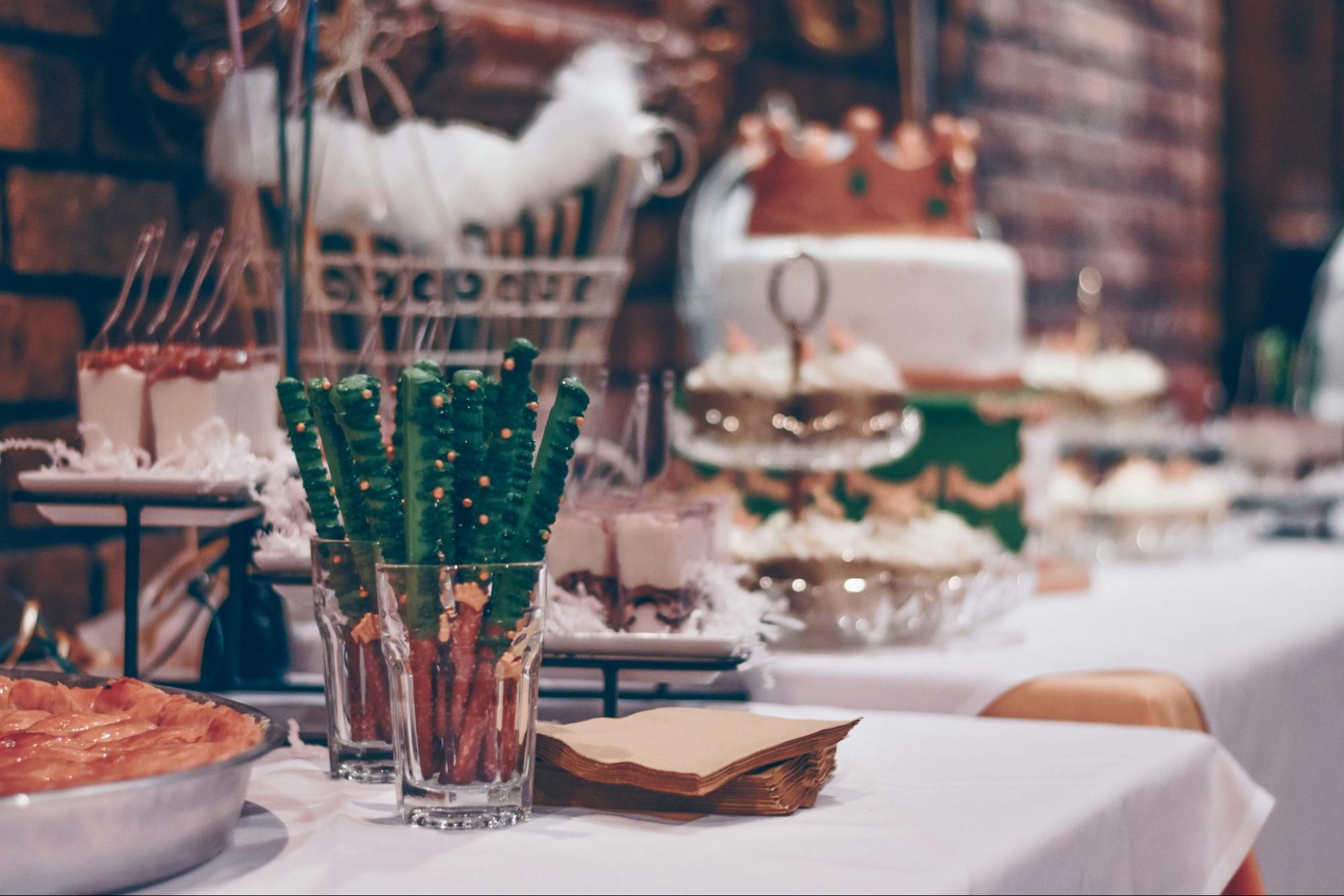 Table at a holiday party with festive desserts and decorations.